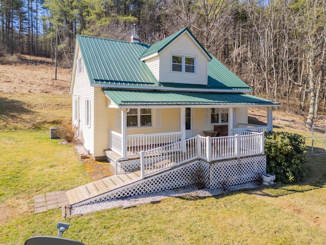 view of front of house featuring metal roof, a porch, and a front yard
