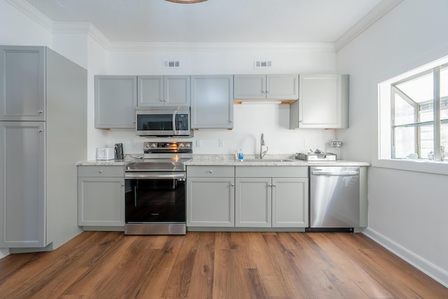 kitchen featuring dark wood finished floors, gray cabinets, a sink, and stainless steel appliances