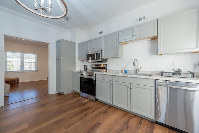 kitchen featuring visible vents, crown molding, stainless steel appliances, a sink, and gray cabinetry