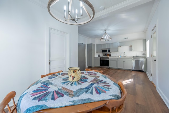 dining room with dark wood-type flooring, visible vents, ornamental molding, and a chandelier