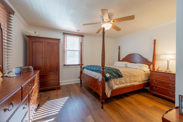 bedroom with dark wood-style flooring, ornamental molding, baseboards, ceiling fan, and visible vents