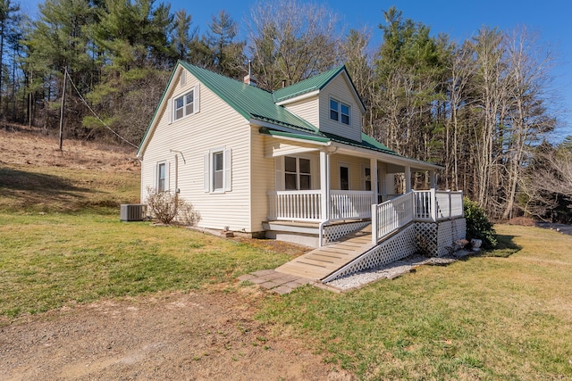 view of front of property with central air condition unit, metal roof, a front yard, and a porch