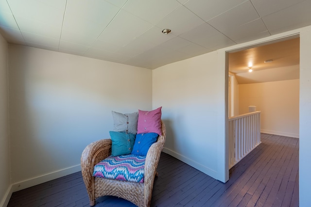 sitting room with baseboards and wood-type flooring