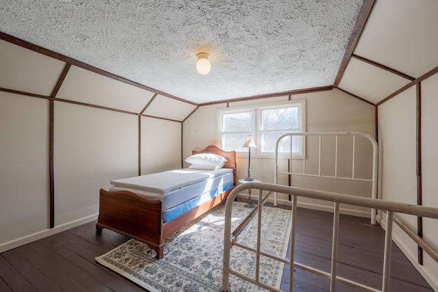 bedroom with lofted ceiling, a textured ceiling, and hardwood / wood-style flooring