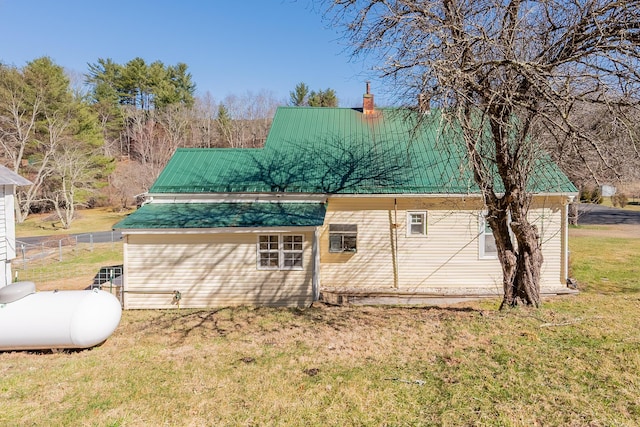 view of property exterior with a chimney and a yard