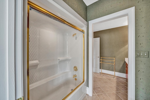 bathroom with tile patterned floors, vanity, baseboards, and bath / shower combo with glass door