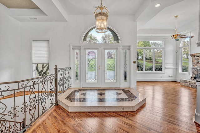 foyer with baseboards, recessed lighting, french doors, ceiling fan with notable chandelier, and wood finished floors