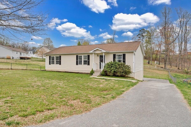 ranch-style home with a front yard, fence, and aphalt driveway