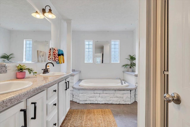 bathroom with a textured ceiling, a wealth of natural light, and a sink
