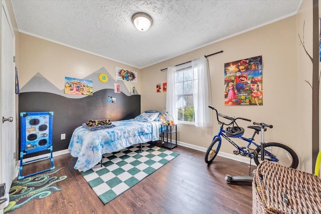 bedroom with baseboards, a textured ceiling, wood finished floors, and ornamental molding
