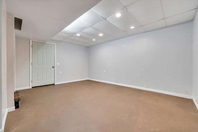 finished below grade area with baseboards, a paneled ceiling, and recessed lighting