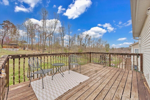 wooden terrace featuring a lawn