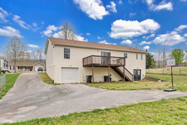 rear view of house with central air condition unit, fence, a wooden deck, an attached garage, and stairway