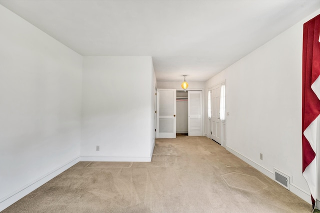 empty room featuring carpet flooring, baseboards, and visible vents