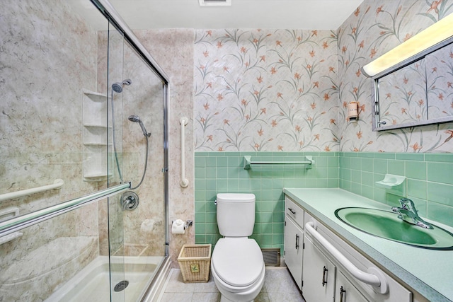full bath with vanity, toilet, wallpapered walls, tile walls, and a stall shower