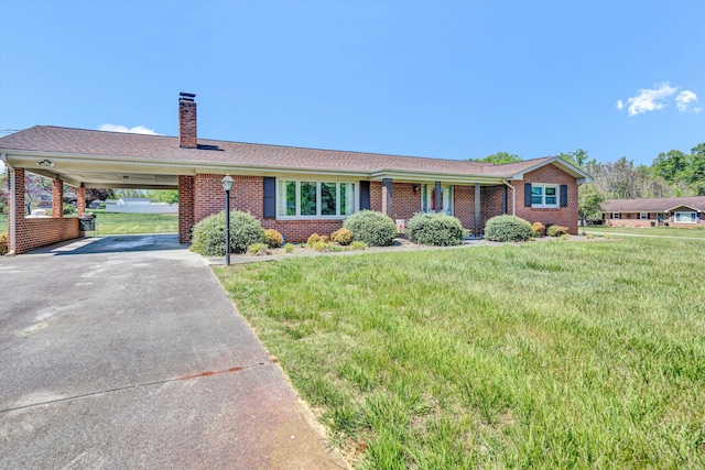 single story home featuring concrete driveway, brick siding, a chimney, and a front lawn