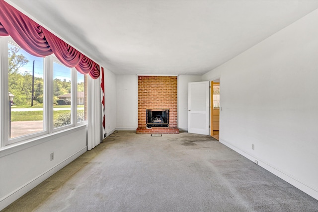 unfurnished living room with baseboards, carpet, and a fireplace