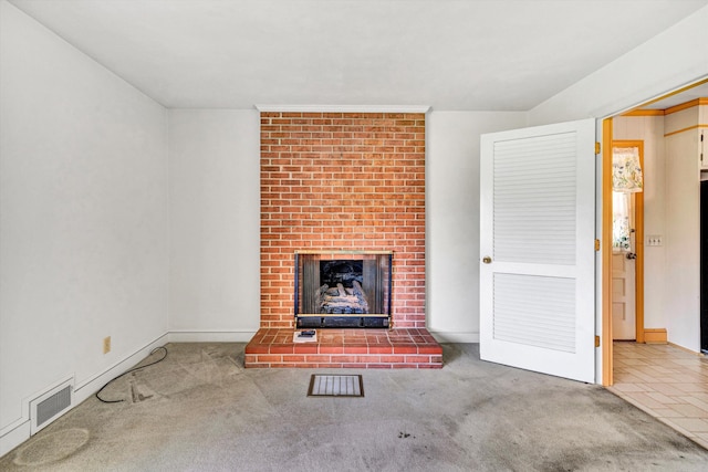 unfurnished living room with a brick fireplace, carpet flooring, visible vents, and baseboards