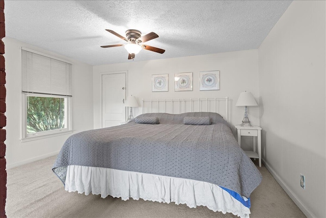 carpeted bedroom featuring baseboards, ceiling fan, and a textured ceiling