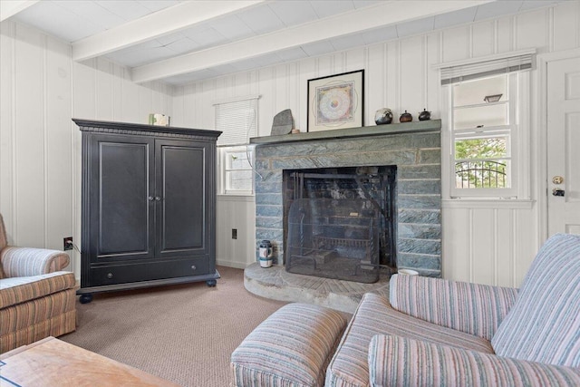 carpeted living area featuring a fireplace, a decorative wall, plenty of natural light, and beam ceiling