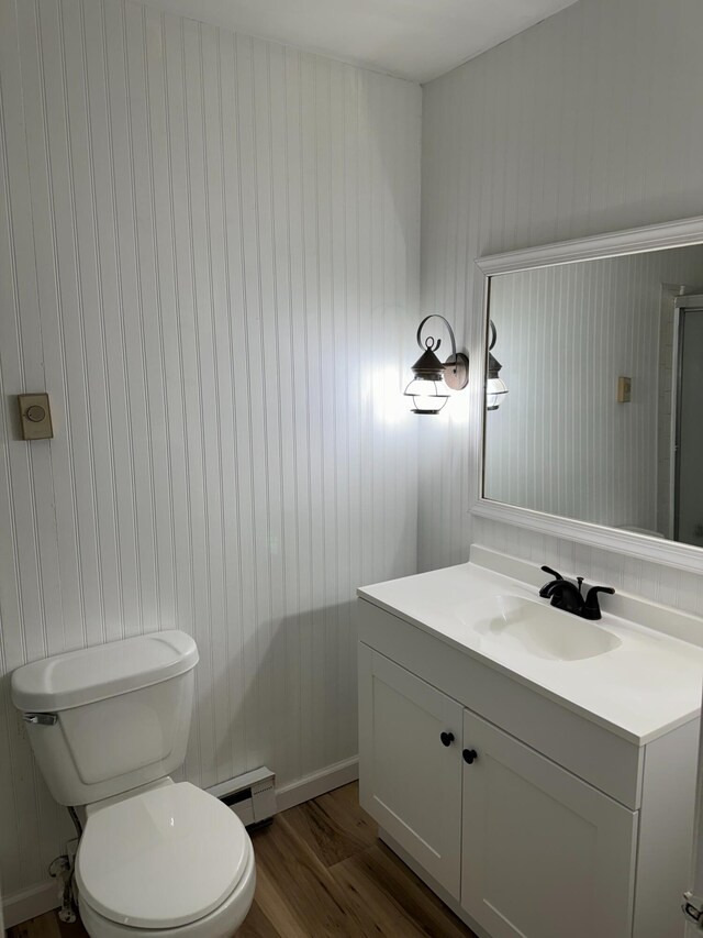 1615 Dolly Ann Dr, Covington, VA 24426 - bathroom featuring wood finished floors, toilet, baseboard heating, and vanity