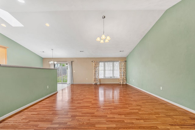 6815 Cee St, Roanoke, VA 24019 - interior space with light wood finished floors, an inviting chandelier, vaulted ceiling with skylight, and baseboards