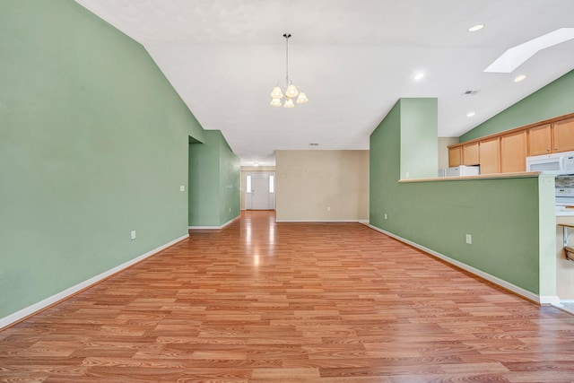 6815 Cee St, Roanoke, VA 24019 - unfurnished living room with an inviting chandelier, light wood finished floors, baseboards, visible vents, and lofted ceiling with skylight