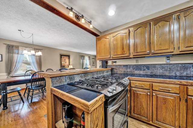 113 Lake Park Dr, Union Hall, VA 24176 - kitchen featuring stainless steel gas range, tile counters, a peninsula, brown cabinets, and light wood-style flooring