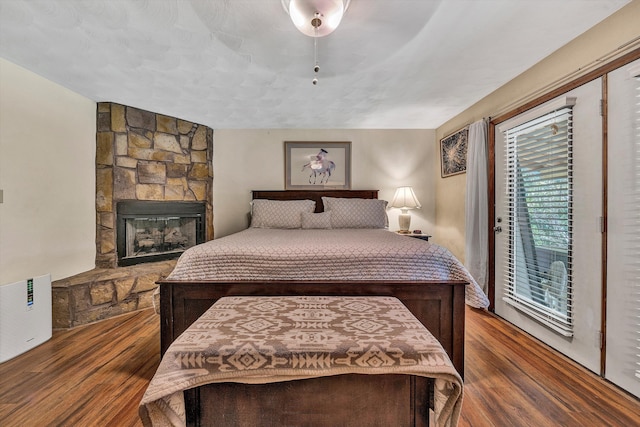 113 Lake Park Dr, Union Hall, VA 24176 - bedroom with access to exterior, wood finished floors, ceiling fan, and a stone fireplace