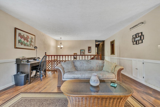 113 Lake Park Dr, Union Hall, VA 24176 - living room with a wainscoted wall, a notable chandelier, wood finished floors, and a textured ceiling