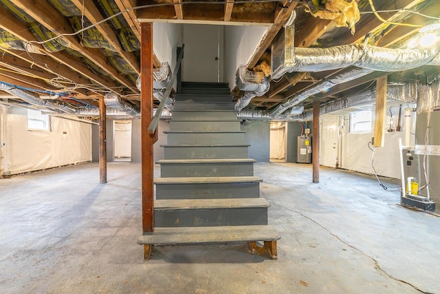below grade area featuring electric water heater, stairway, and a wealth of natural light