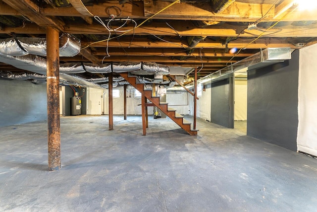 unfinished basement featuring stairs and electric water heater