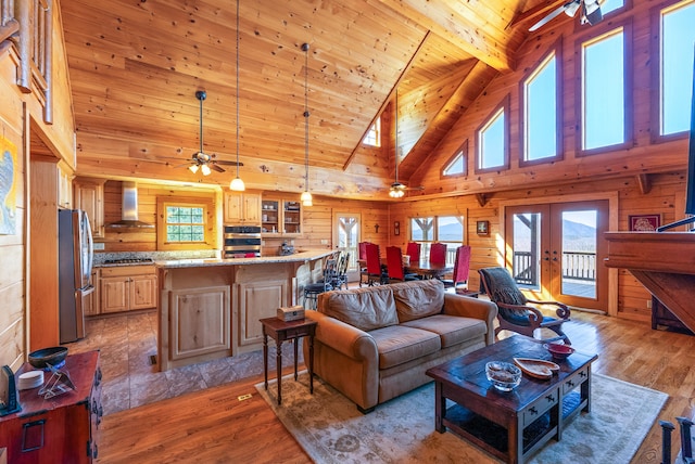 living room with wooden ceiling, wooden walls, light wood-style floors, and a ceiling fan