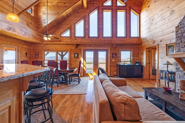 living area featuring wood walls, french doors, and light wood-type flooring
