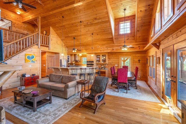 living room featuring wooden walls, wood ceiling, and a ceiling fan