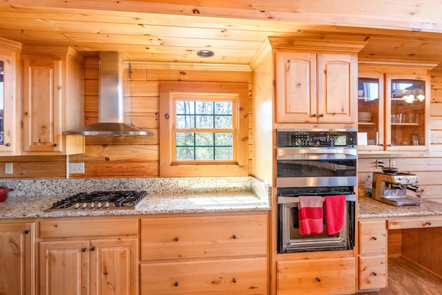 kitchen with stainless steel gas cooktop, wall chimney exhaust hood, double wall oven, and light brown cabinets