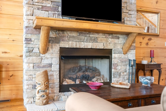 details featuring a fireplace, visible vents, and wooden walls