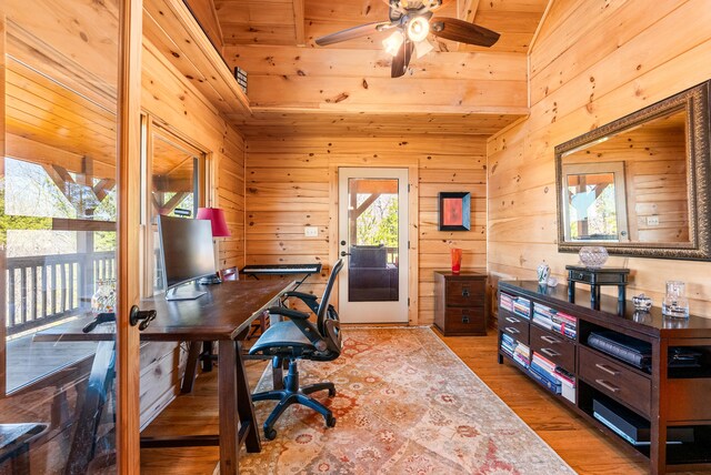 office featuring ceiling fan, wood finished floors, and wood walls