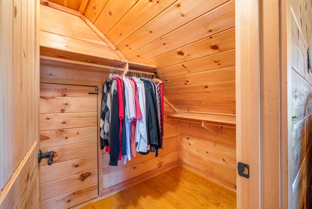 spacious closet with wood finished floors and vaulted ceiling