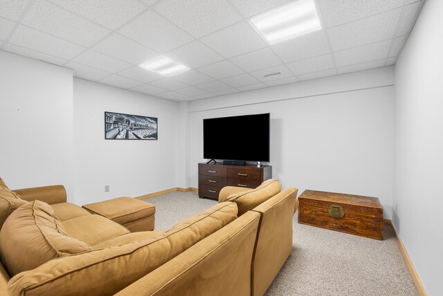 carpeted living room featuring baseboards and a paneled ceiling