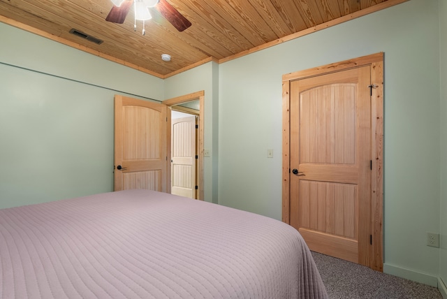 unfurnished bedroom featuring carpet floors, visible vents, ceiling fan, and wood ceiling