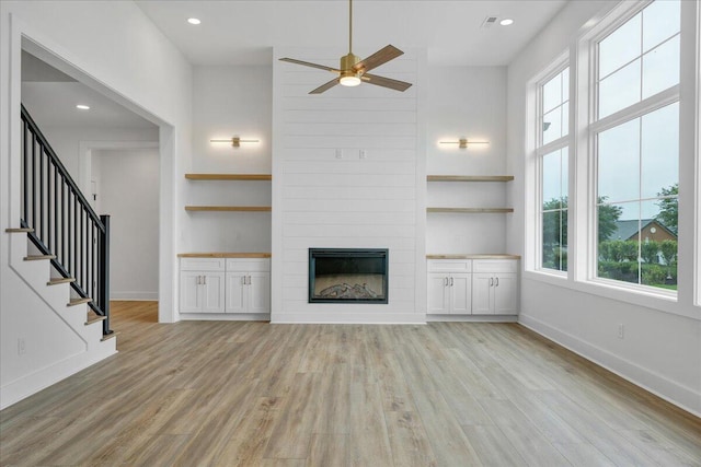 1050 Westerham Ct, Huddleston, VA 24104 - unfurnished living room with plenty of natural light, a ceiling fan, a large fireplace, light wood-type flooring, and a towering ceiling