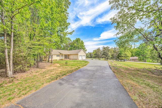 view of front of property featuring a front lawn, driveway, and an attached garage