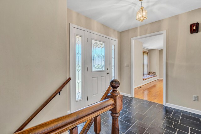 entryway featuring baseboards and stone finish floor