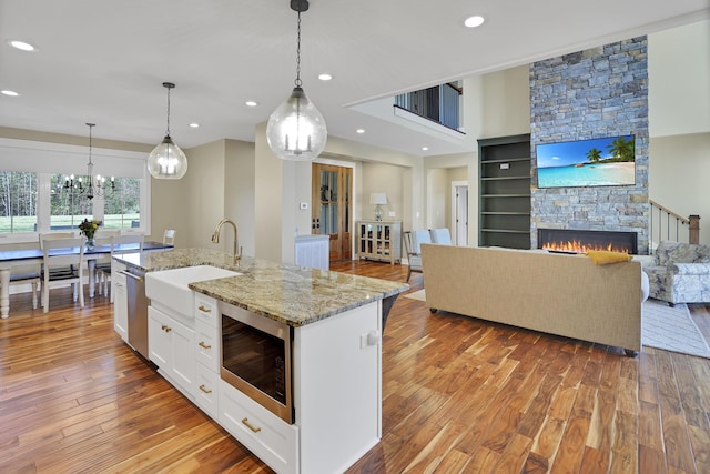 kitchen with light wood-style flooring, white cabinetry, a sink, stainless steel appliances, and open floor plan