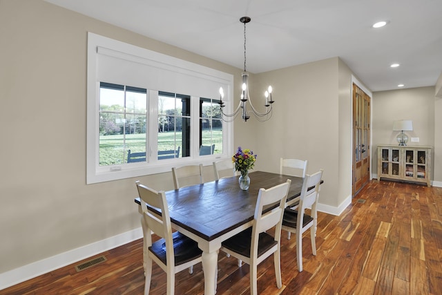 dining space with baseboards, wood finished floors, a notable chandelier, and visible vents