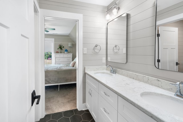 full bathroom featuring tile patterned floors, double vanity, ensuite bath, and a sink