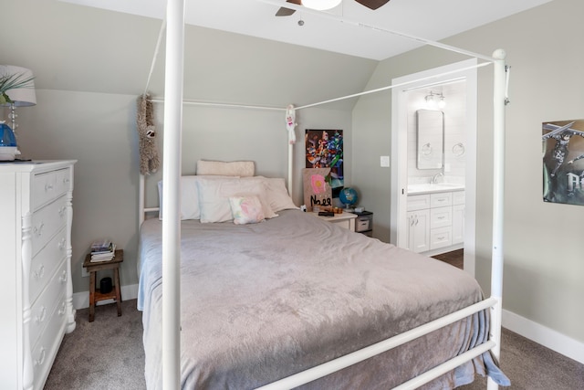 bedroom with ensuite bath, carpet floors, a sink, lofted ceiling, and baseboards