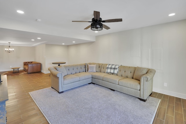 living room featuring wood finished floors, ceiling fan with notable chandelier, baseboards, and recessed lighting