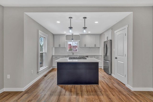 535 Day Ave SW, Roanoke, VA 24016 - kitchen with baseboards, light countertops, a kitchen island, decorative backsplash, and appliances with stainless steel finishes